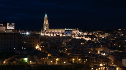 Panoramic view of the historic center of Toledo, Spain, at night with its illuminated Santa Maria Cathedral and San Ildefonso Church. UNESCO World Heritage Site