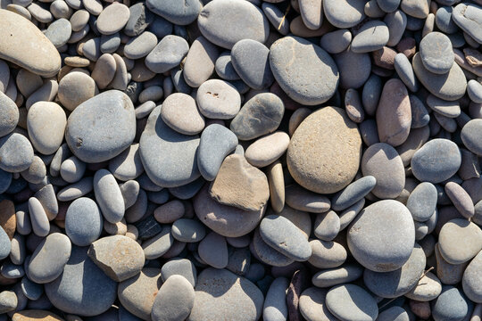 Small round rocks on the beach, sea coast. Clean wallpaper.