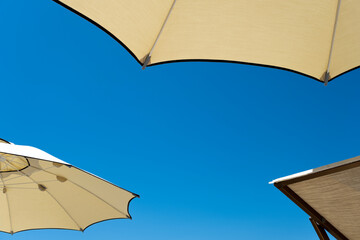 Umbrellas and chaise longues with blue skies