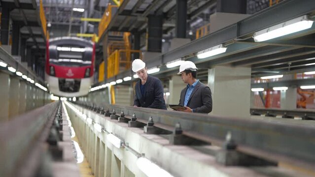 Engineer with blueprints prepare to inspect electric train machinery according to the inspection cycle. Before the electric train enters the train repair tracks. 