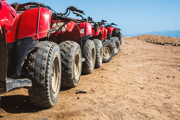Red quads stand in a row on the shore of the Red Sea. Dahab, Egypt. - obrazy, fototapety, plakaty