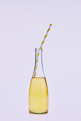 Bottle of delicious sweet and sour lemonade with straw isolated over light background. Concept of drink, food, taste, refreshment, summer