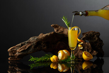 Traditional Italian liqueur Limoncello on a black reflective background. - obrazy, fototapety, plakaty
