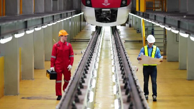 Engineer with blueprints prepare to inspect electric train machinery according to the inspection cycle. Before the electric train enters the train repair tracks. 
