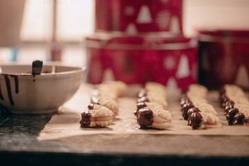 Shortbread cookies, gluten-free, sugar-free, marzipan filling, dipped in chocolate (with coconut blossom sugar); homemade,in the background 3 red cookie jars