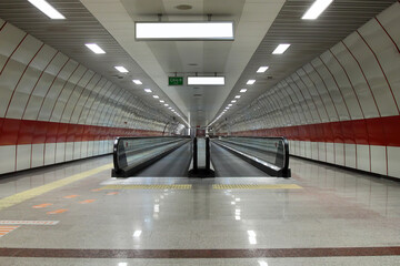 moving escalator in subway station. Walkway with Blank billboard located in underground hall or...