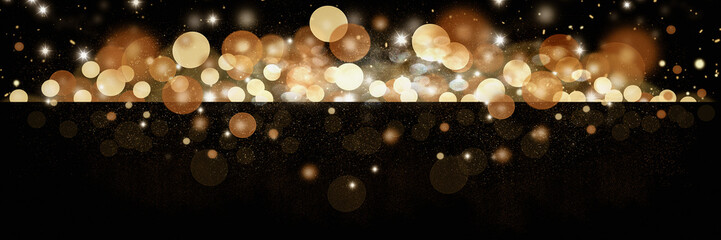 Beautiful sparkly blurred gold toned glitter bokeh banner over black background. Perfect for New Years Day or Christmas. 
