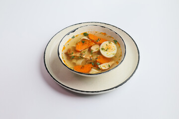 Bowl of broth with tender chicken fillet with egg isolated on white background. Lunch time