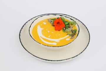 Tasty pumpkin Soup with cream in a bowl on a white background