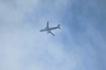 Fototapeta na wymiar Ein Flugzeug auf dem Himmel, der hinter den Wolken fliegt