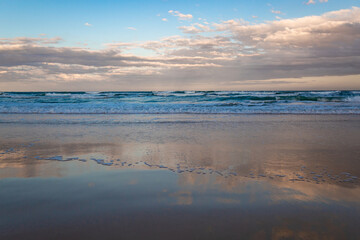 ondas e reflexo do céu no pôr-do-sol da  Praia do Santinho Florianópolis Brasil