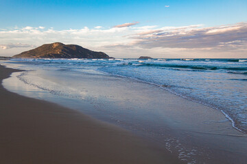 onda quebrando no areia ao pôr-do-sol  na Praia do Santinho Florianópolis Brasil