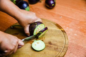 Woman cutting eggplant on the cutting board