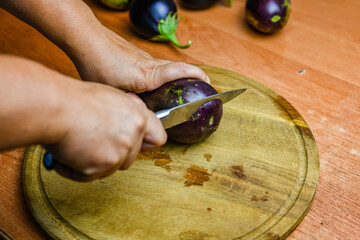 Woman cutting eggplant on the cutting board