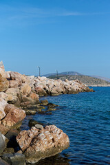 Fototapeta na wymiar Tranquil, azure sea with rocky shore, vertical photo
