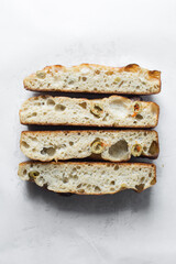 homemade olive focaccia on a white background, Flatlay of focaccia with green olive topping, fresh homemade focaccia bread