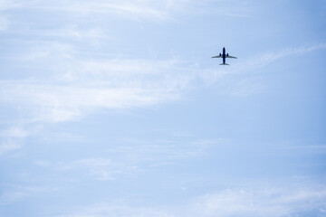 Blue Airplane Flying in the Sky with Clouds