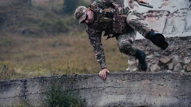 Military Officer Jumps over the Wall with a Pistol