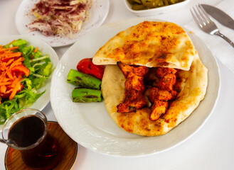 Traditional Turkish grilled chicken skewers Shish taouk with bread, fresh and pickled vegetables