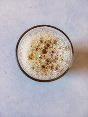 Glass cup of moroccan green tea with white foam and beautiful bubbles. Moroccan sweet hot drink made of green tea and natural mint.