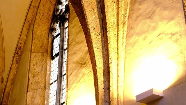 St.Magdalens Chapel, church interior with arches and high vaulted ceilings, warm sunlight pouring through windows, history and cultural richness, architectural masterpieces, Austria, Hall in Tirol
