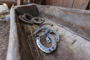 Old and new horseshoes on a wooden background.