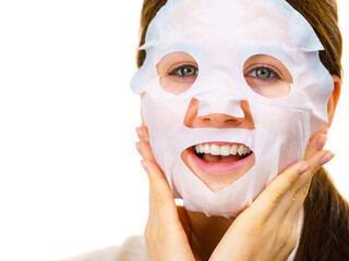 Woman applying sheet mask on face