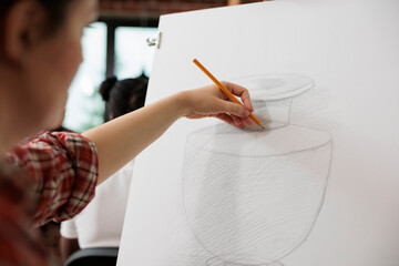 Creative process. Female artist sketching and shading vase with pencil, learning to draw and sketch at art school, woman enjoying drawing as hobby attending creative workshop to develop creativity