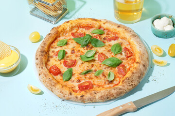 Tasty pizza Margarita with tomatoes and basil on blue table