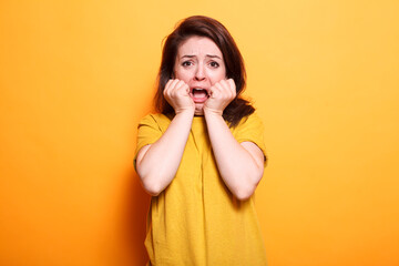 Terrified person with shocked expression standing over isolated orange background. While looking at...