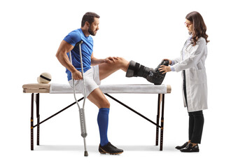 Fototapeta na wymiar Doctor checking an injured football player with a foot brace