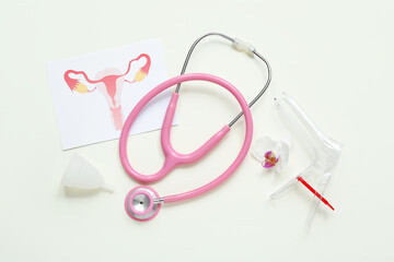 Fototapeta premium Gynecological speculum, drawing of female uterus, menstrual cup and stethoscope on white background