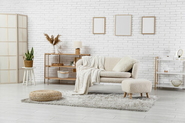 Interior of light living room with sofa and shelving units