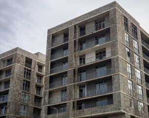 A gloomy gray building. Unfinished brutalist house. Concept of crisis in construction. Gray architecture. Cloudy autumn weather. Concrete house for people.