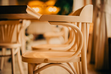 Photo of an empty wooden elegant chair in a cafe, standing near the table. The interior of the...