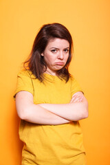 Obraz premium Portrait of female individual with arms crossed feeling sad and disappointed on camera. Distraught caucasian lady showing unhappy facial expression of frustration and depression.