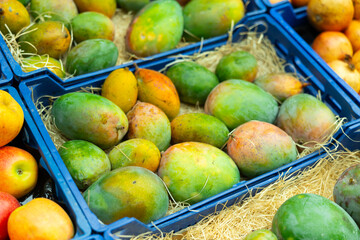 Bunch of sweet mangoes lie on counter in vegetable store