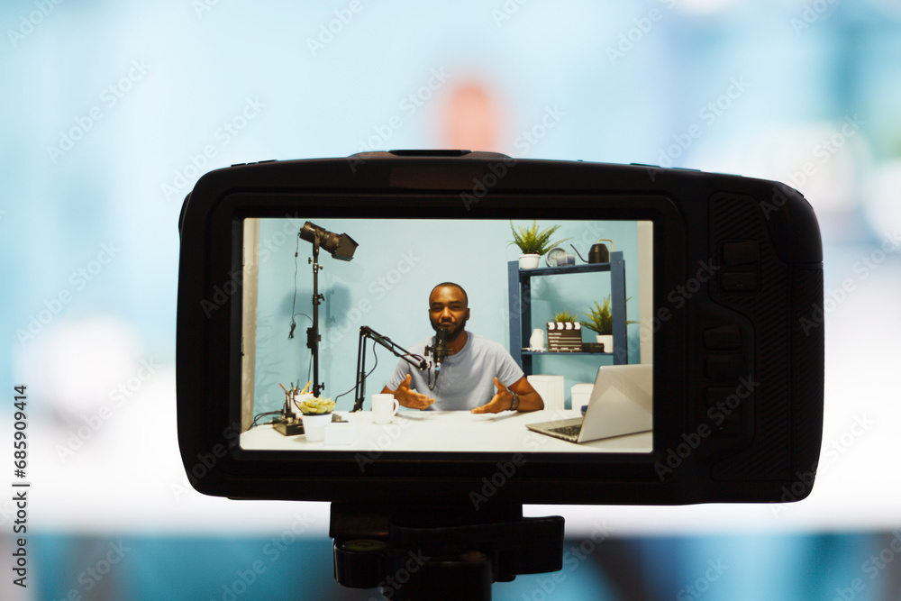 Poster african american blogger on camera screen speaking to subscribers while recording video with profess