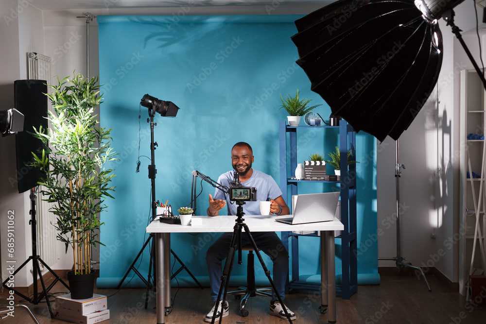 Poster blogger connecting with subscribers while speaking in microphone and live streaming in studio. smili