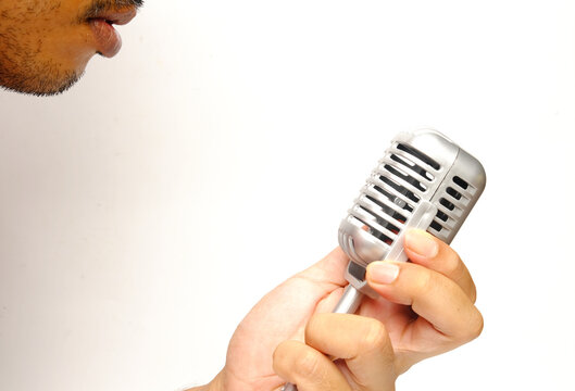 A picture of men holding classical microphone on isolated white background.