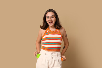 Young woman with condoms on beige background. Safe sex concept