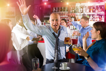 Portrait of man in unbuttoned shirt dancing at corporate party