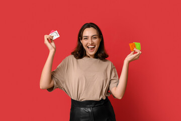 Happy young woman with condoms on red background. Safe sex concept