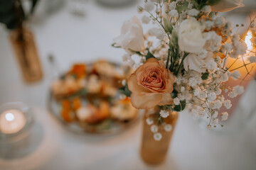 Beautiful wedding decorations on the restaurant with roses, greenery and orchid flowers