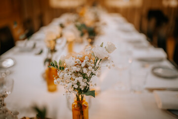 Beautiful wedding decorations on the restaurant with roses, greenery and orchid flowers