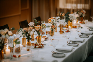 Beautiful wedding decorations on the restaurant with roses, greenery and orchid flowers