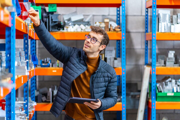 Engineer using tablet in the stock room of a factory