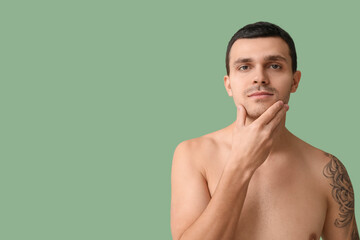 Handsome young man with bristle on green background
