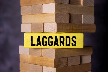A yellow wooden block and the inscription Laggards on it - obrazy, fototapety, plakaty