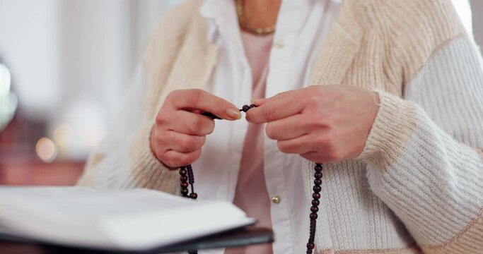 Hands, woman and bible with rosary for praying, spiritual faith and holy trust to worship God at home. Closeup, christianity and prayer beads for religion, gospel books and praise to Jesus Christ
